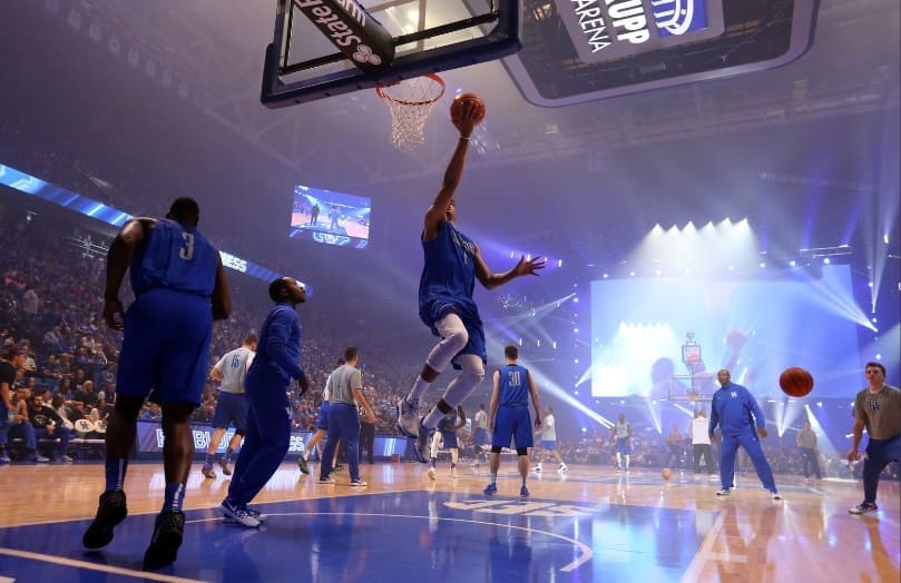 Basketball player soaring for a slam dunk during a game.