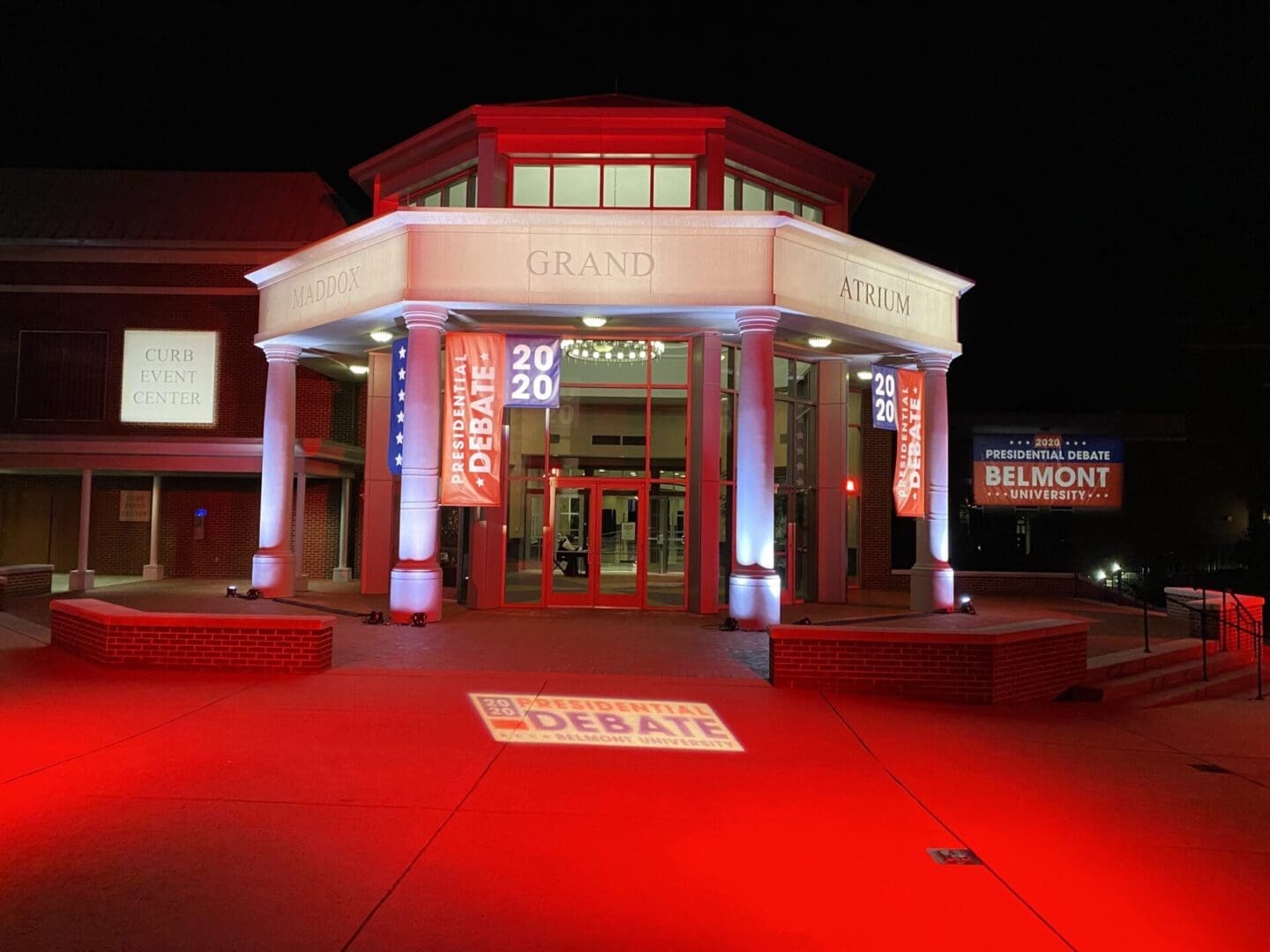 Entrance of a building illuminated in red light during nighttime.