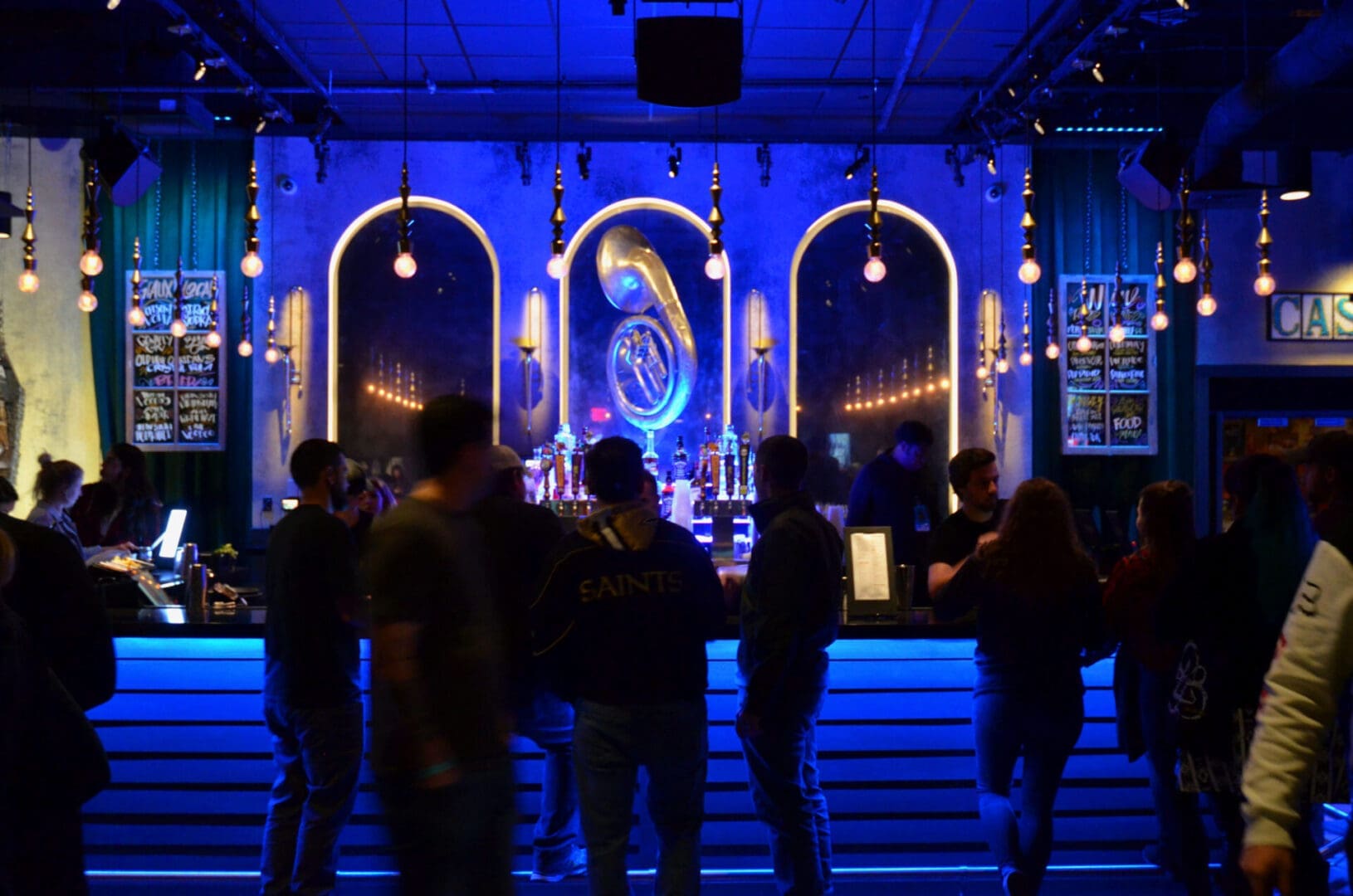 People socializing in a dimly lit nightclub with neon lights.