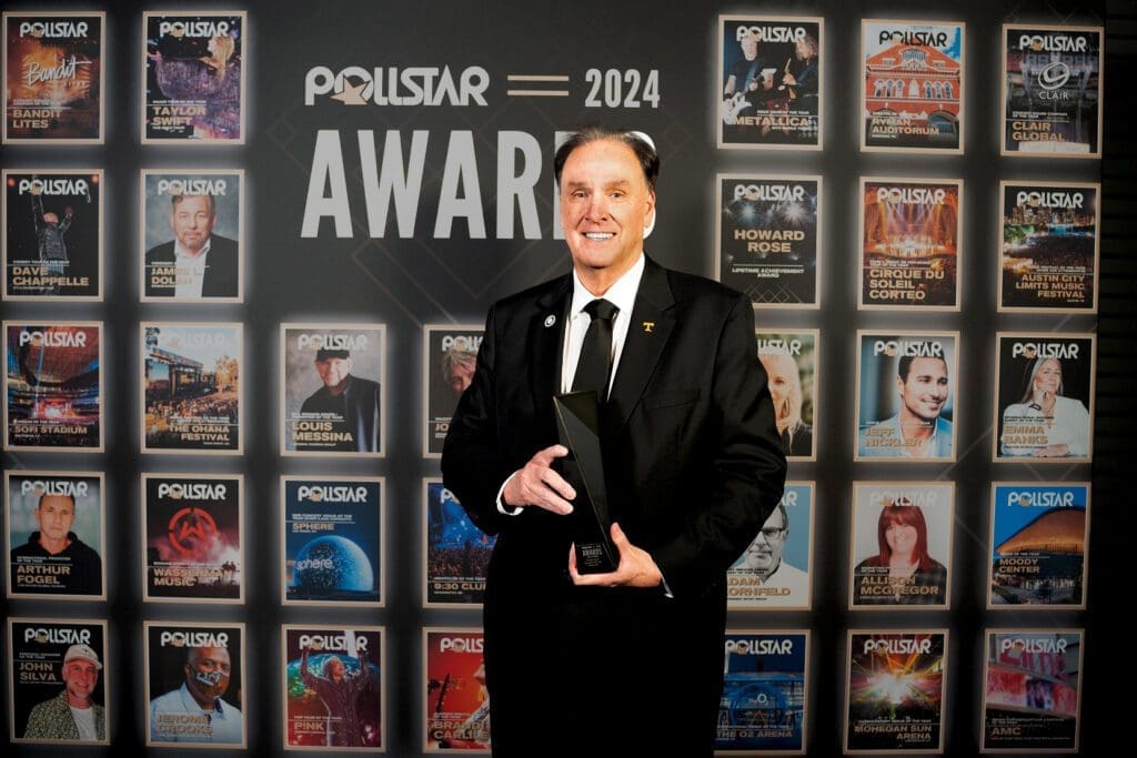 A man in a black suit holding an award at the Polestar 2024 Awards.