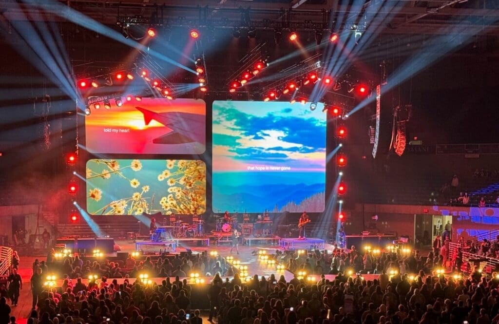 A vibrant concert stage with colorful screens and glowing lights.