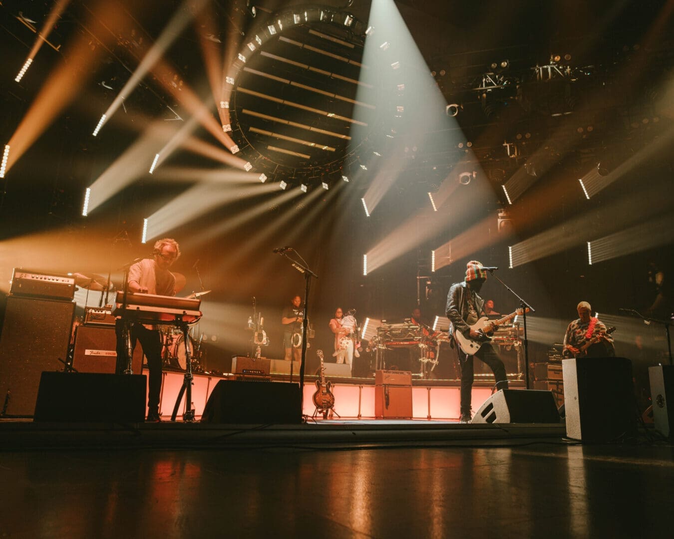 A live band performs energetically on a stage with dramatic lighting.