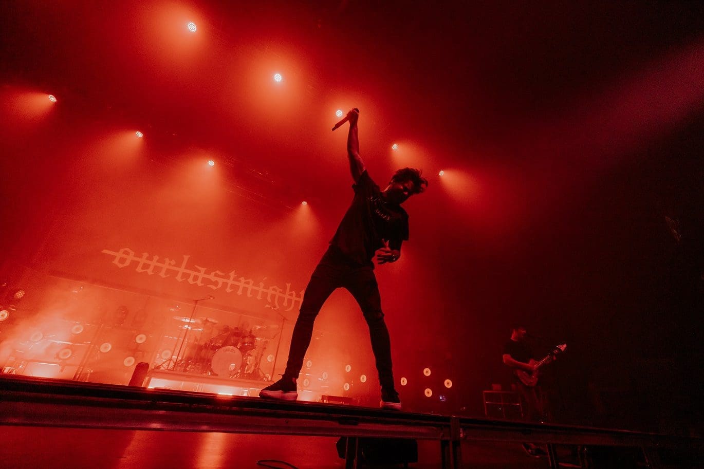 Silhouette of a performer on stage with dramatic red lighting.