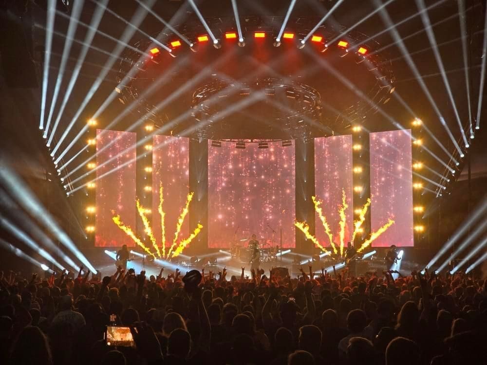 A vibrant concert stage with colorful lights and a lively crowd.