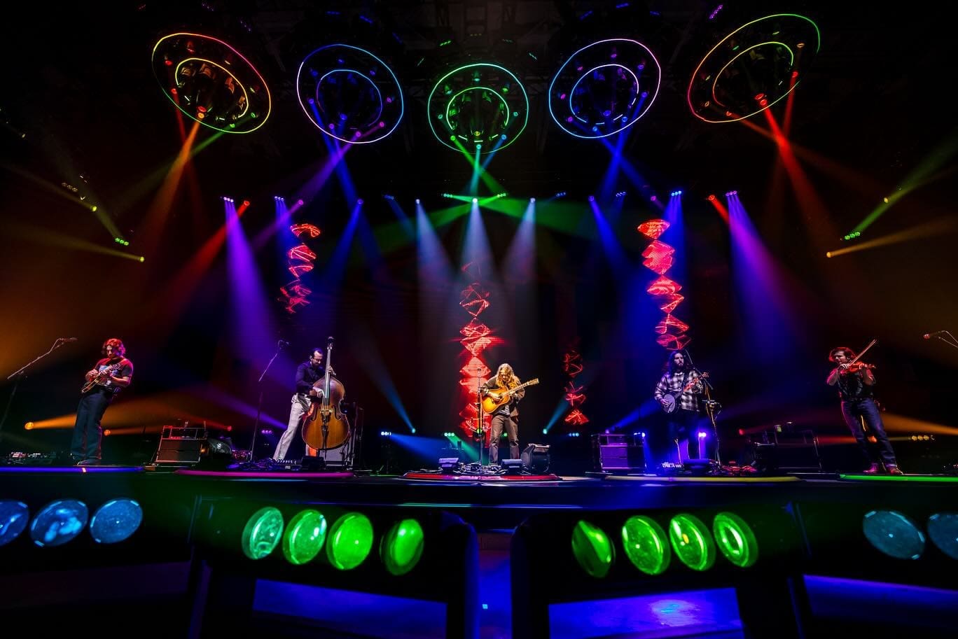 A vibrant stage performance with colorful lights and musicians playing instruments.