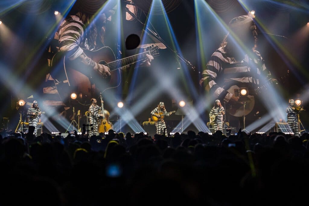 Live concert with vibrant stage lighting and a large audience.