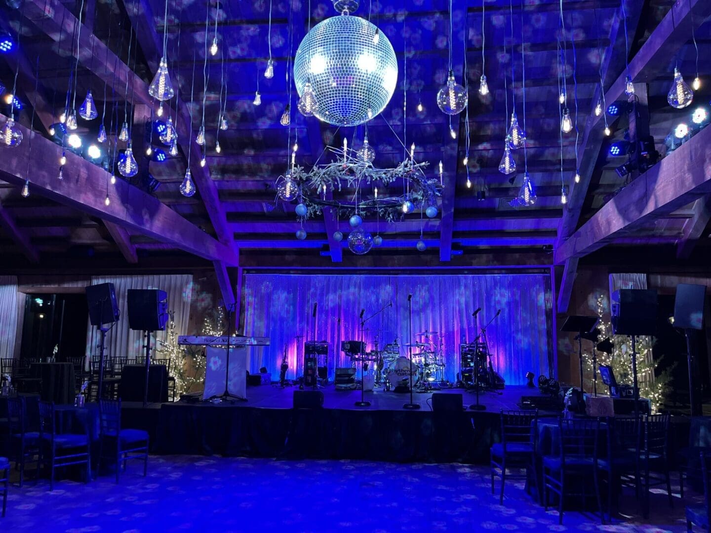 A dimly lit event space with blue and purple lighting and a disco ball.