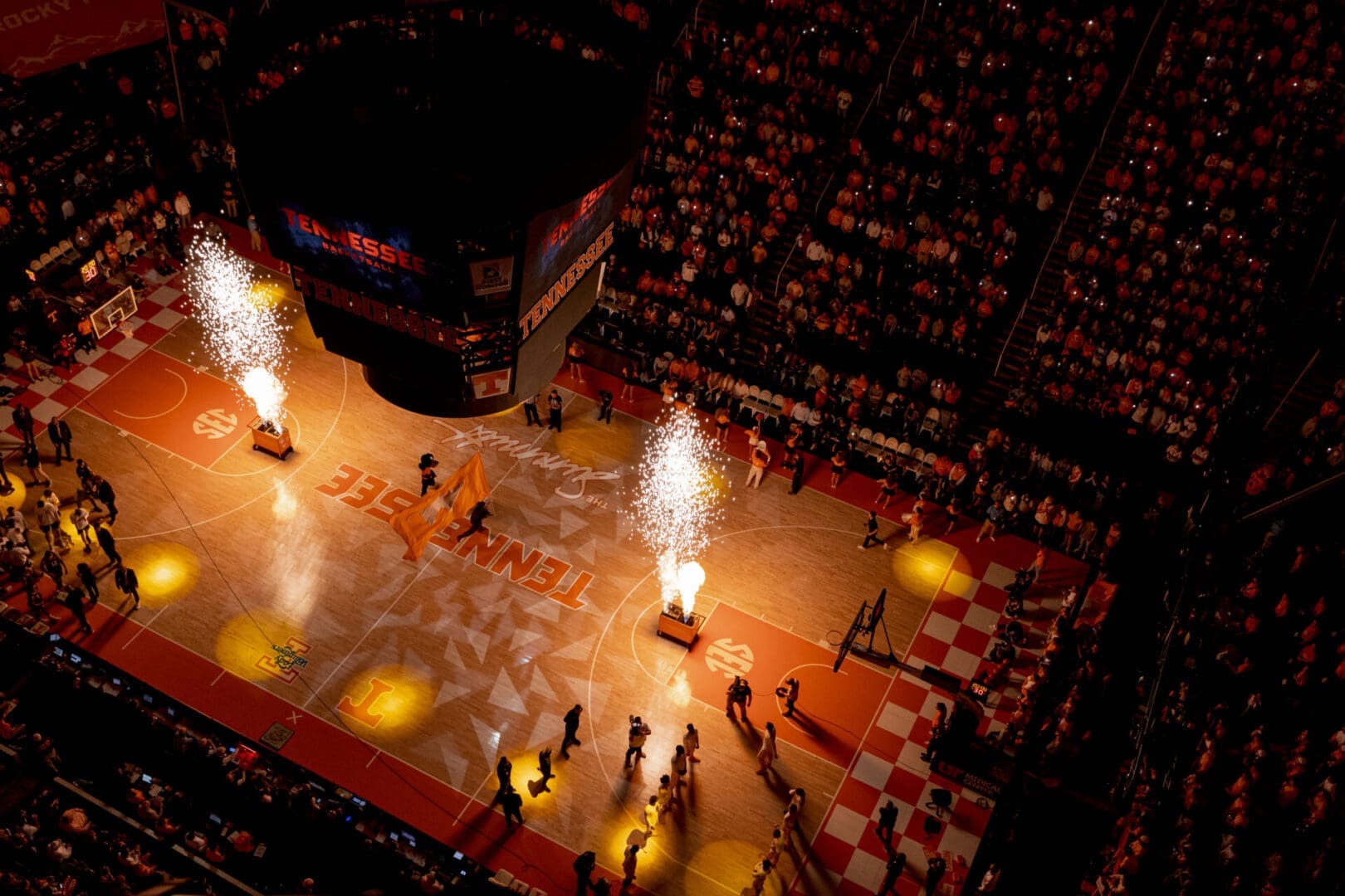 UT Basketball players entering the rink amid fiery pyrotechnics and a cheering crowd.