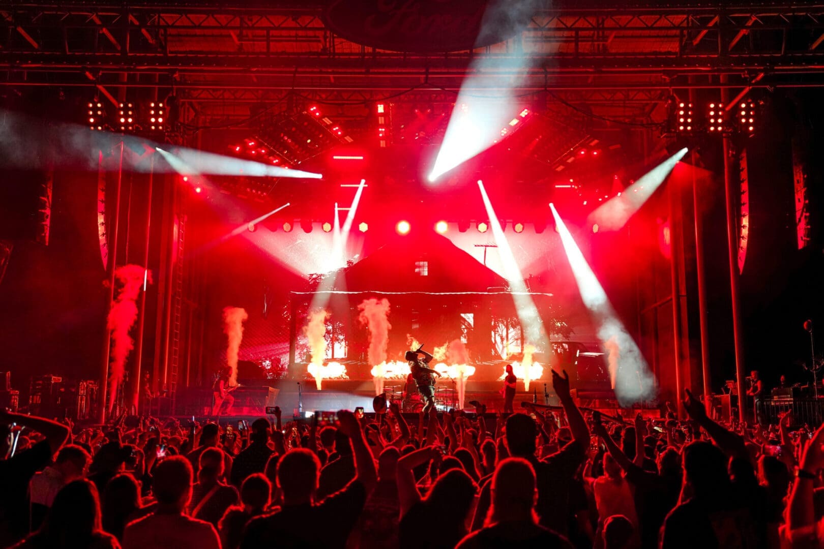 A lively concert with bright red lights and an excited crowd.
