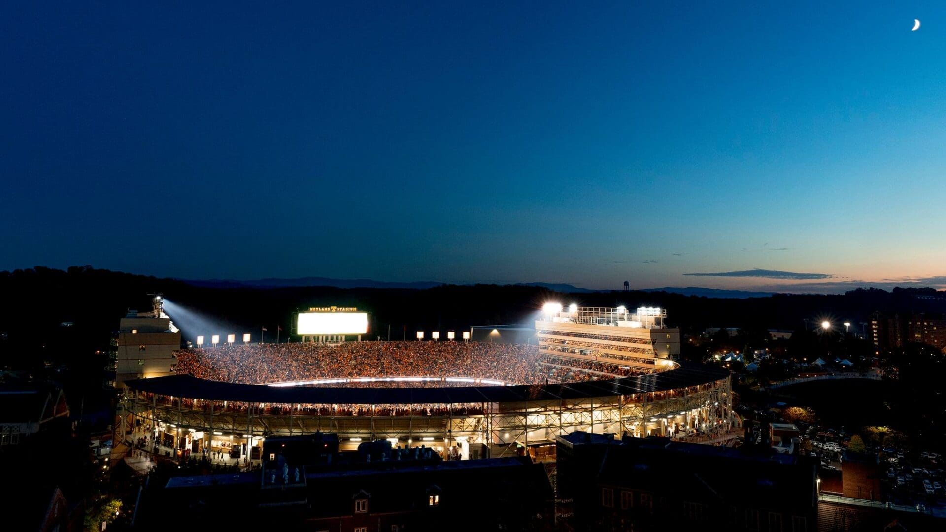 A brightly lit stadium under a deep blue night sky.
