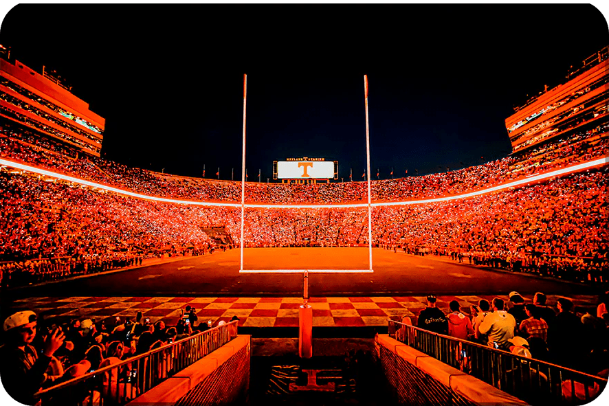A brightly lit football stadium at night with an empty field.