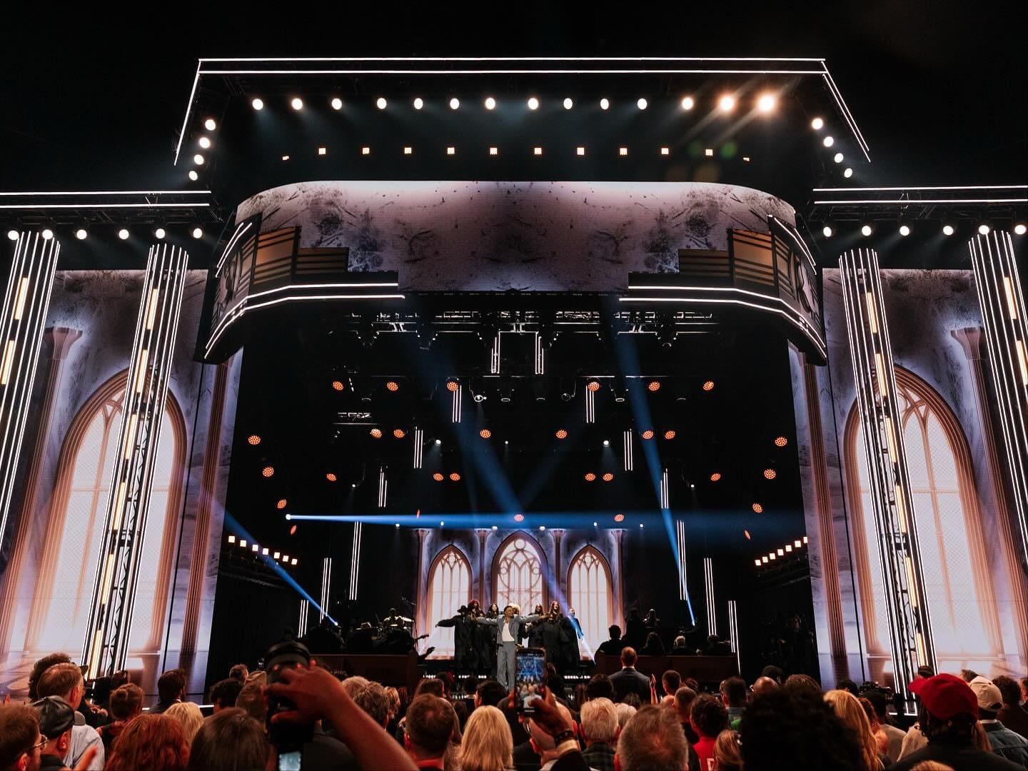 A lively concert with bright stage lights and an enthusiastic crowd.