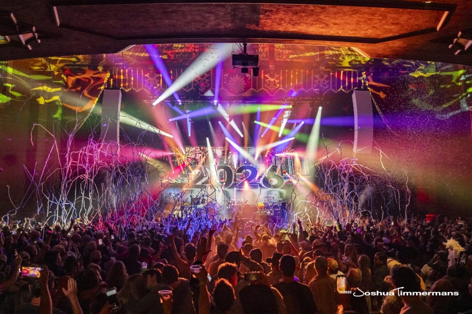 Energetic concert with vibrant lights and a packed crowd.