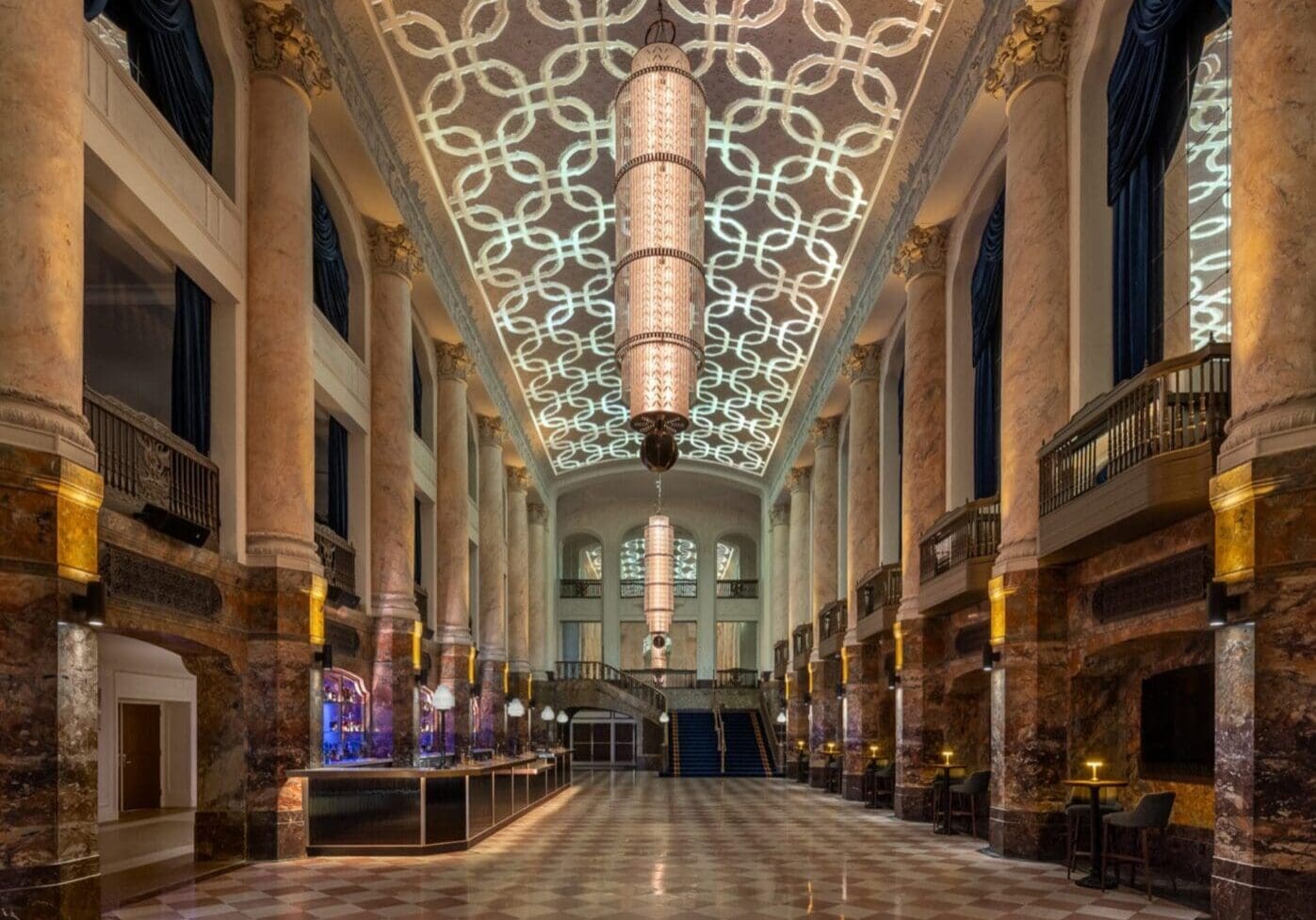 Elegant grand hall with intricate ceiling and polished floor.