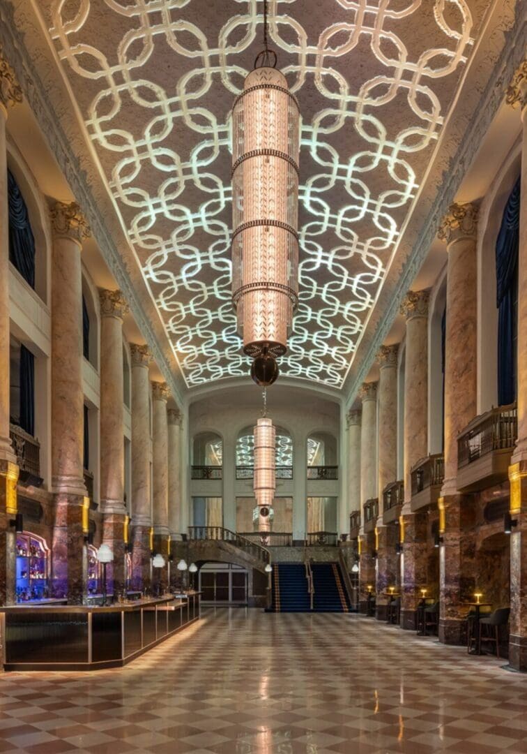 Elegant grand hall with intricate ceiling and polished floor.