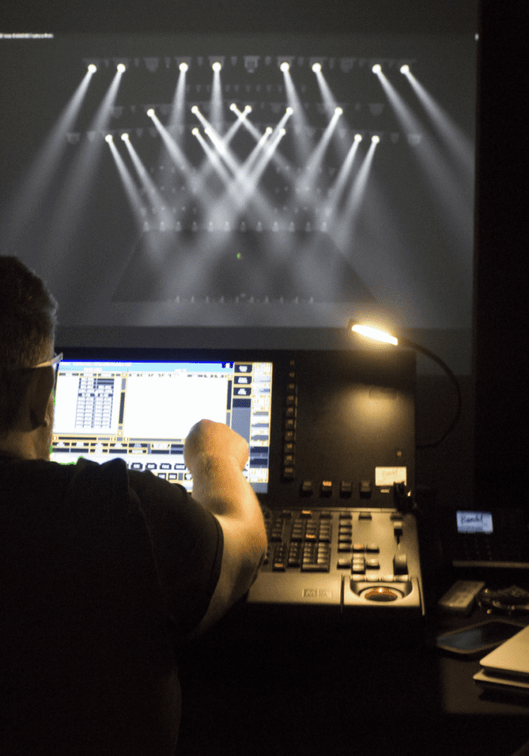 Technician managing lighting controls during a live event.